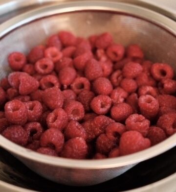 Fresh raspberries in a steel colander